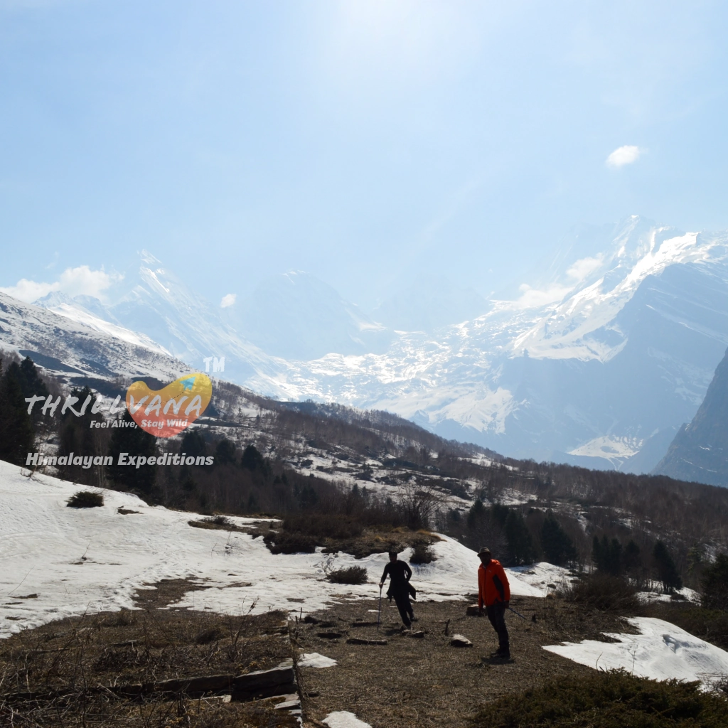 Wide view of trekkers exploring the massive, snow-covered mountain peaks of the Darma Valley with Thrillvana.